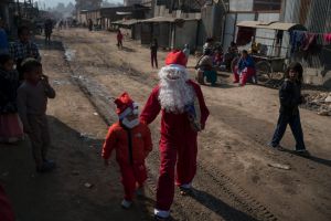 KATHMANDU, KATHMANDU - DECEMBER 25: Christians wearing Santa costumes celebrate Christmas in a slum area on December 25, ...