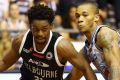 Melbourne United's Casper Ware drives to the basket against Jerome Randle of the Adelaide 36ers.