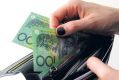 Woman removes hundred dollar bills from her purse / wallet generic cash Australina money notes AFR MARKET WRAP