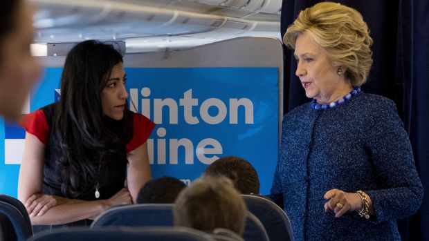 Mrs Clinton speaks with senior aide Huma Abedin aboard her presidential campaign plane.