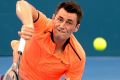 First-round exit: Tomic serves against Spaniard Ferrer.