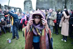 A woman wears a costume as people gather at Stonehenge in Wiltshire western England.