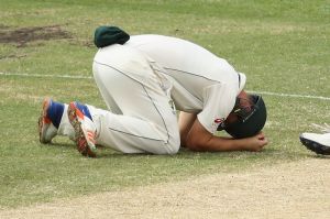 Painful blow: Hilton Cartwright of Australia lies on the ground after being struck in the groin.