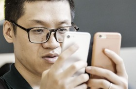 A customer inspects two Apple Inc. iPhone 7 smartphones at the Apple Store inside the IAPM shopping mall in Shanghai, ...