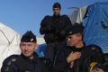 French police search through migrant tents at the "Jungle" before authorities demolish the site on Tuesday.