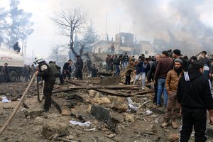 Rescue workers attend to the wreckage after they and Syria’s opposition activists say dozens were killed when a car bomb went off in a busy market in a rebel-held Syrian town of Azaz along the Turkish border, Saturday, Jan. 7, 2017.