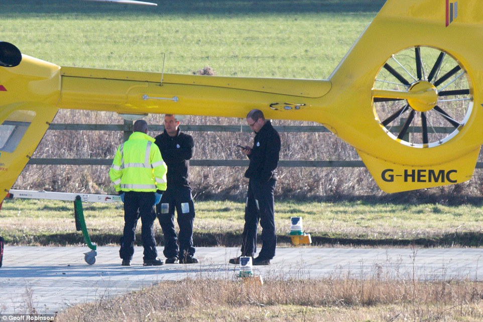 Prince William was seen checking his mobile phone by the East Anglian Air Ambulance at Addenbrooke's hospital in Cambridge