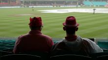 Like watching paint dry: Two fans during the rain delay at the Sydney Cricket Ground on the third day of the Test.