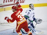 Vancouver Canucks goalie Jacob Markstrom, right, of Sweden, looks away as Calgary Flames' Alex Chiasson celebrates his goal during third-period NHL hockey ga...