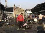 Citizens inspect the scene after a car bomb explosion at a crowded outdoor market in the Iraqi capital's eastern district of Sadr City, Iraq, Sunday, Jan 8, ...