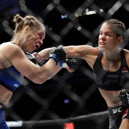 Amanda Nunes, right, connects with Ronda Rousey in the first round of their women's bantamweight championship mixed martial arts bout at UFC 207, Friday, Dec. 30, 2016, in Las Vegas. Nunes won the fight after it was stopped in the first round. (AP Photo/John Locher)