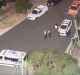 Ambulance and police vehicles are seen on McIntosh Street, Sunshine, after a woman was shot in the arm.