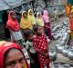 Rohingya women and children wait in a queue to collect water at the Leda camp, an unregistered camp for Rohingya in ...