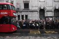 Commuters queue for buses at Victoria Station.