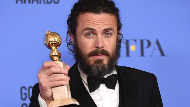 Casey Affleck poses in the press room with the Golden Globe award for his performance in 'Manchester by the Sea'.