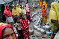 Rohingya women and children wait in a queue to collect water at the Leda camp, an unregistered camp for Rohingya in ...