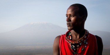 A Maasai warrior stands in his homeland as Africa's tallest mountain, the snow-capped Mt Kilimanjaro, stands in the ...