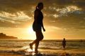 A woman walks along the water's edge at Bondi Beach ahead of another baking day for Sydney.