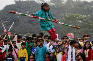 Indians watch Rani, 7, perform a rope balancing act at a public park on the first day of the New Year, in Kolkata.