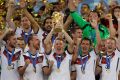 FILE - In this July 13, 2014 file photo Germany's Bastian Schweinsteiger holds up the World Cup trophy as the team ...