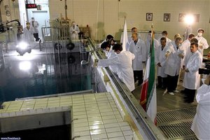 In this Feb. 15, 2012, file photo, provided by the Iranian President's Office, Iranian President Mahmoud Ahmadinejad, right, is escorted by technicians during a tour of Tehran's research reactor center in northern Tehran, Iran.