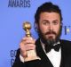 Casey Affleck poses in the press room with the Golden Globe award for his performance in 'Manchester by the Sea'. 