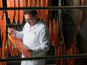 Lance Anisfeld, here inspecting smoked salmon, is commonly known as Lance Forman to match the name of the family-founded company he heads.