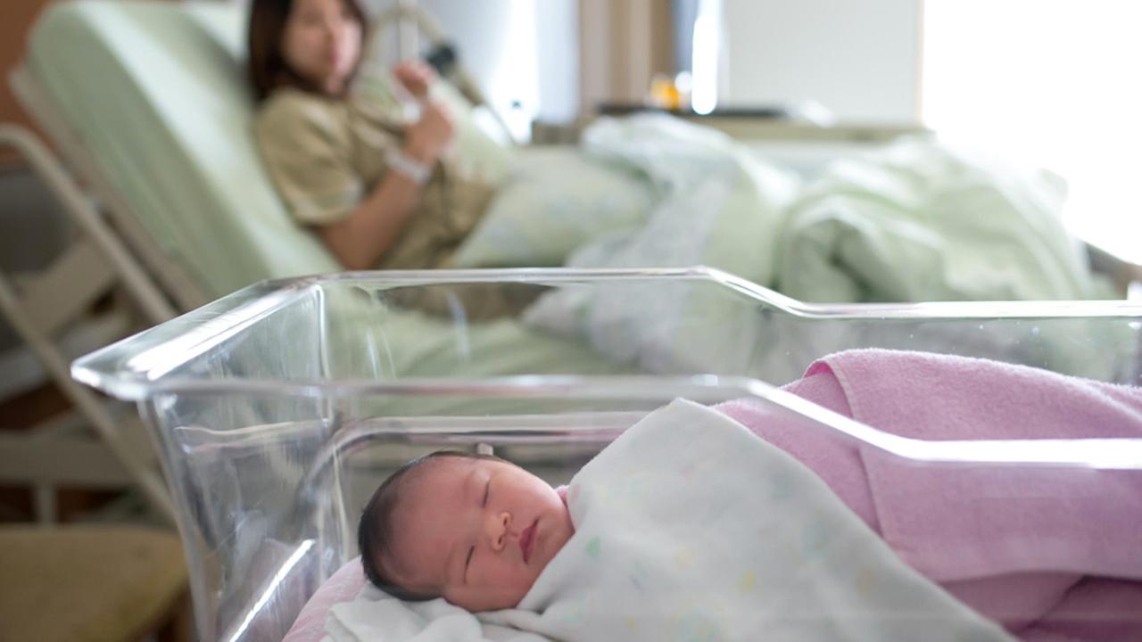 A newborn baby in the hospital with its mother.