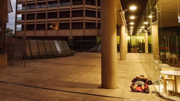 A homeless man spends the night outside the State Library of NSW, in sight of Premier Mike Baird's parliamentary office, ...