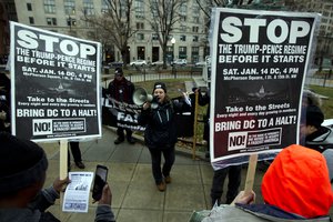 Demonstrators hold banners as they protest in opposition of President-elect Donald Trump, at McPherson Square, in Washington, Saturday, Jan. 14, 2017.