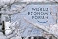 A sign for the World Economic Forum annual meeting sits on display among snow covered trees in Davos, Switzerland, on ...