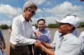 US Secretary of State John Kerry, left, shakes hands with Vo Ban Tam, 70, right, who was a Viet Cong guerrilla and took ...