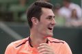 Bernard Tomic laughs during a change of ends in his match against Gilles Simon at Kooyong.