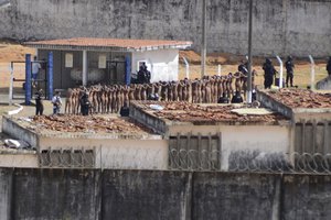 Naked inmates stand in line while surrounded by police after a riot at the Alcacuz prison in Nisia Floresta, Rio Grande do Norte state, Brazil