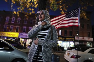 Enas Almadhwahi, an immigration outreach organizer for the Arab American Association of New York, stands for a photo along Fifth Avenue in the Bay Ridge neighborhood of Brooklyn, Friday, Nov. 11, 2016, in New York. American Muslims are reeling over Donald Trump's victory