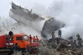 Firefighters work among remains of a crashed Turkish Boeing 747 cargo plane at a residential area outside Bishkek, ...