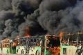 Smoke rises from green government buses awaiting to evacuate residents in Idlib province, Syria on Sunday.