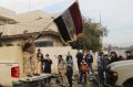 An Iraqi soldier waves the national flag as security forces patrol on the eastern side of Mosul, Iraq, on January 18. 