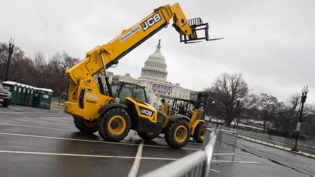 A forklift stands in front of security fences near the US Capitol building. Reported inauguration plans such as a parade ...