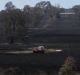 A fire truck refills from a dam inside Paul Davis' property after crews worked through the night on Wednesday to put out ...