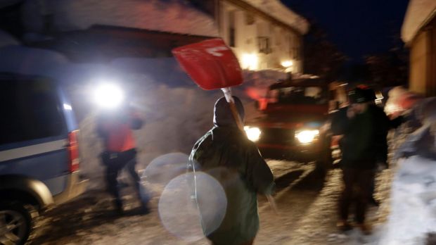 A man walks with a shovel as rescue operations take place in the town of Farindola, central Italy.