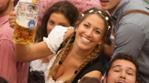 MUNICH, GERMANY - SEPTEMBER 17: Visitors hold up one-litre glasses of beer to kick off the 2016 Oktoberfest beer ...