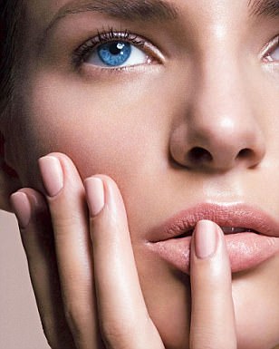 069300-005   FOR EDITORIAL USE ONLY. CLEAR MODEL RIGHTS FOR COVER USE. Close up of female face with her fingers resting on her cheek, little finger on her lips, bright blue eyes, thick eyebrows and sheer foundation, pale blusher and pale pink lips in 'Paparazzi (Chanel) and pale pink nail varnish 'Flamme Rose' (Chanel). Obligatory Credit - CAMERA PRESS / Madame Figaro / Michael Wirth