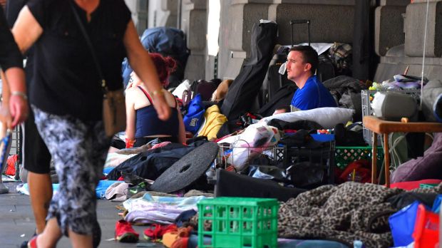 A man sits at the homeless camp outside Flinders Street Station.