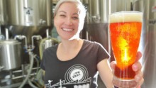 Jayne Lewis from Two Birds Brewing holds a glass of the award-winning Sunset Ale.