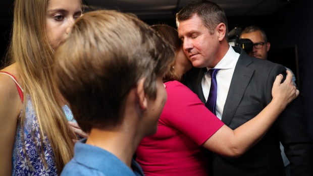 Premier Mike Baird embraces his family after a press conference annpuoncing his resignation in Sydney.