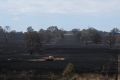 A fire truck refills from a dam inside Paul Davis' property after crews worked through the night on Wednesday to put out ...