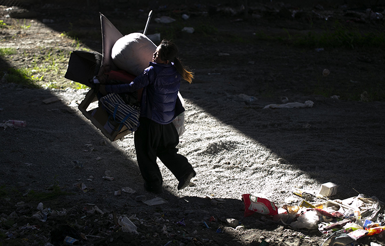 “China,” a homeless camper underneath Interstate 5 on South Jackson Street hurries to pack up as maintenance workers from the Washington State Department of Transportation arrive to clear encampments Wednesday April 6, 2016.