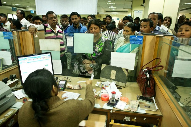 Indians deposit discontinued notes on the last eligible day in a bank in Gauhati, India , Friday, December 30.