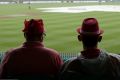 Like watching paint dry: Two fans during the rain delay at the Sydney Cricket Ground on the third day of the Test.
